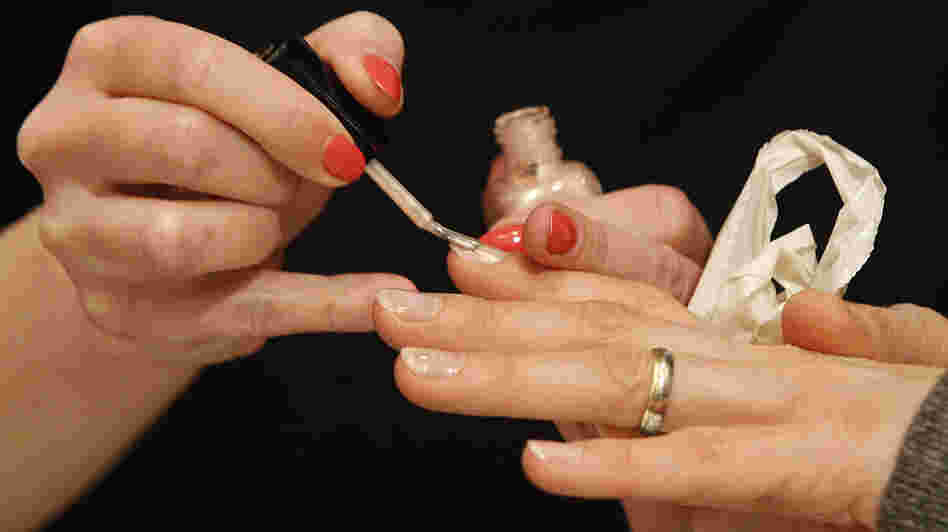 A worker paints fingernails with O2M polish at an Inglot shop in a Polish shopping center. The breathable nail polish has become a hit with Muslim women.