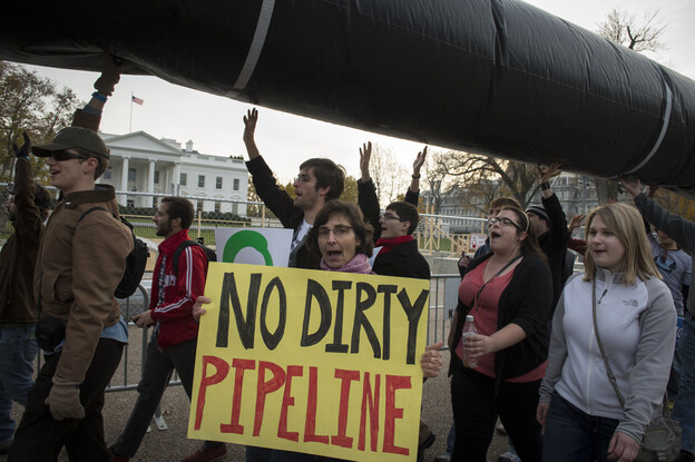Demonstrators carry a mock pipeline as they pass the White House to protest the Keystone Pipeline, in Washington, D.C., on Nov. 18, 2012.