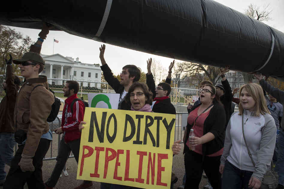 Demonstrators carry a mock pipeline as they pass the White House to protest the Keystone Pipeline, in Washington, D.C., on Nov. 18, 2012.