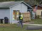 After a sinkhole swallowed a man in his bedroom in Seffner, Fla., an engineer tethered with a safety line walks in front of a home on Saturday.