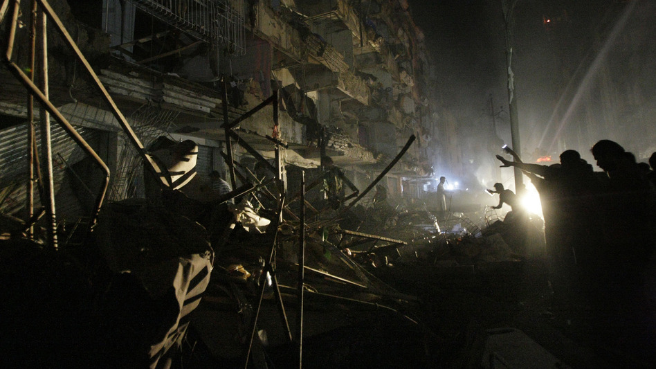 Pakistanis check the site of a bomb blast in Karachi on Sunday. Pakistani officials say the blast has killed dozens of people in a neighborhood dominated by Shiites.