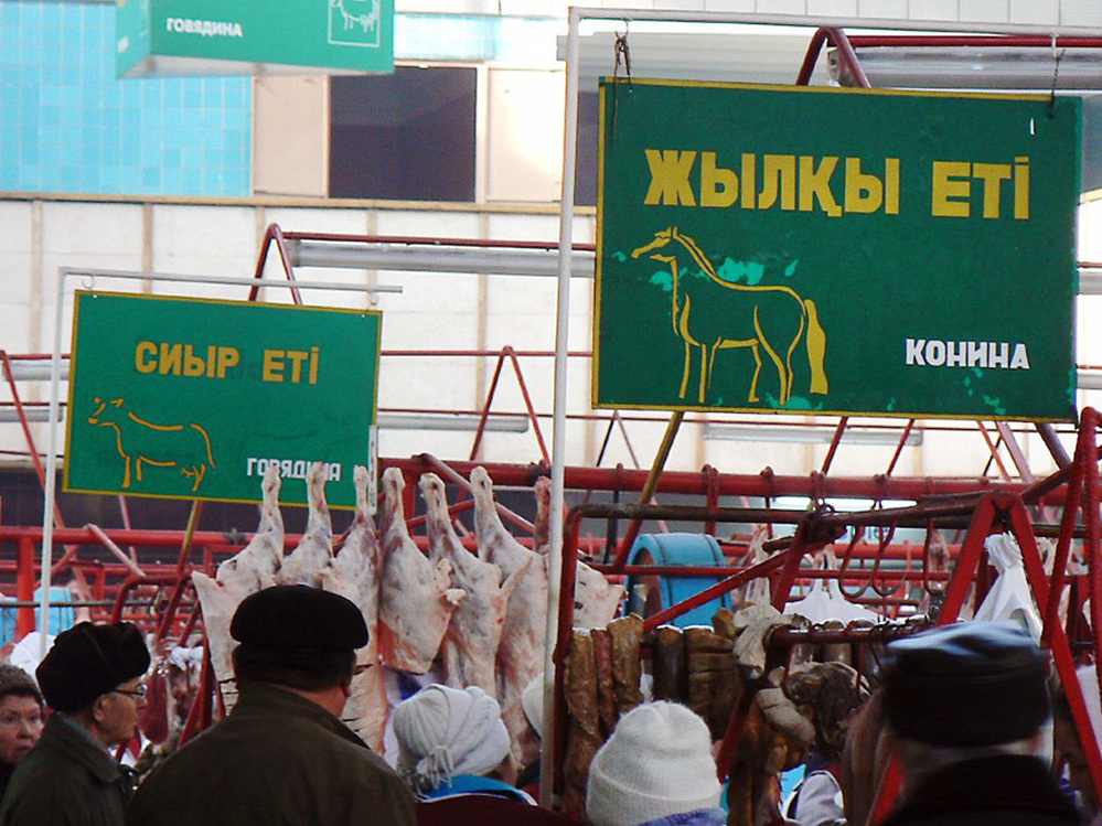Signs advertise the type of meat sold in each section of the Green Market in Almaty, Kazakhstan.