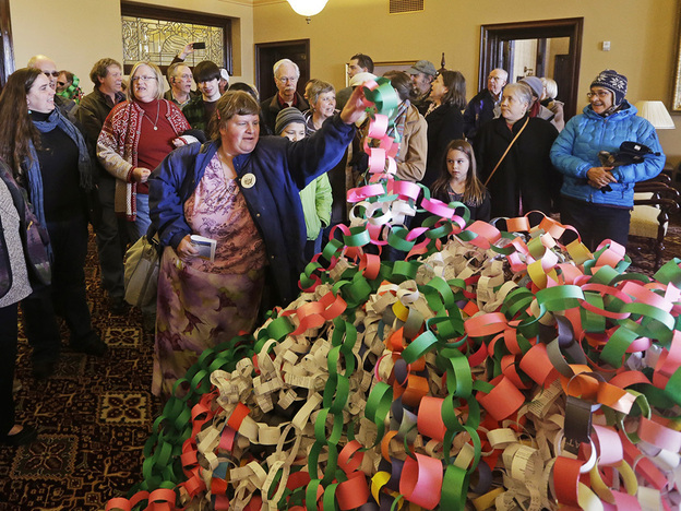 Outside the office of Utah Gov. Herbert Friday, Betsy Ogden lays paper chains on a pile symbolizing uninsured state residents who would be covered by a Medicaid expansion.