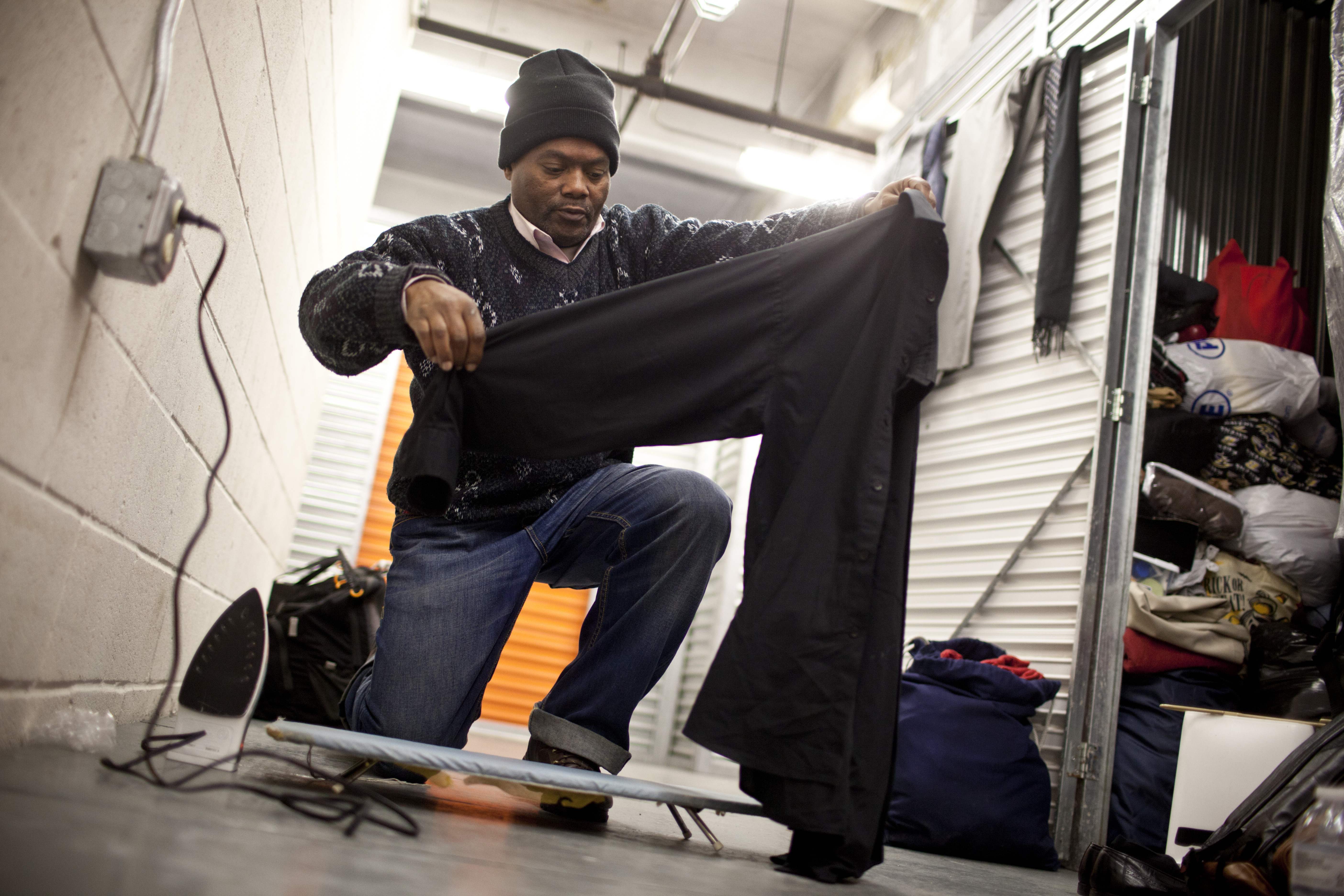 Simmons irons a dress shirt at his storage unit, which he shares with three other homeless men, in preparation for the hearing. A father of three, he became homeless after a 2011 drug arrest and has been staying in shelters for 14 months.