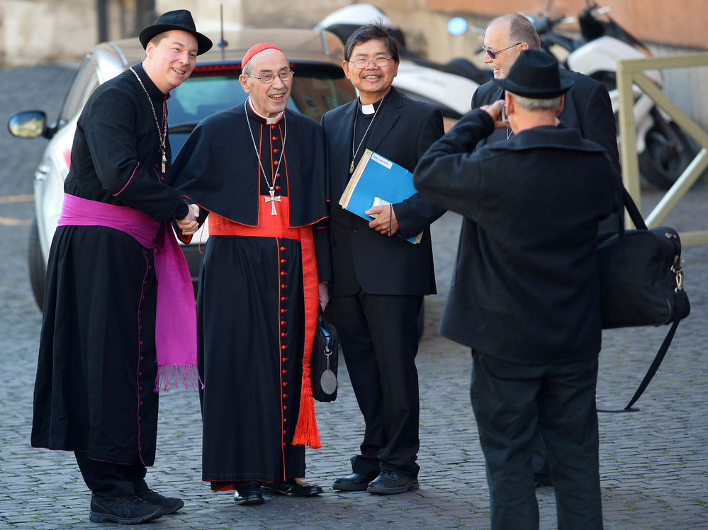 That's not a real bishop on the left: A man later identified as Ralph Napierski of Germany (at left) posed with Cardinal Sergio Sebiastiana and others on Monday at the Vatican. Napierski was an imposter. He was later escorted from the area by Swiss Guards.