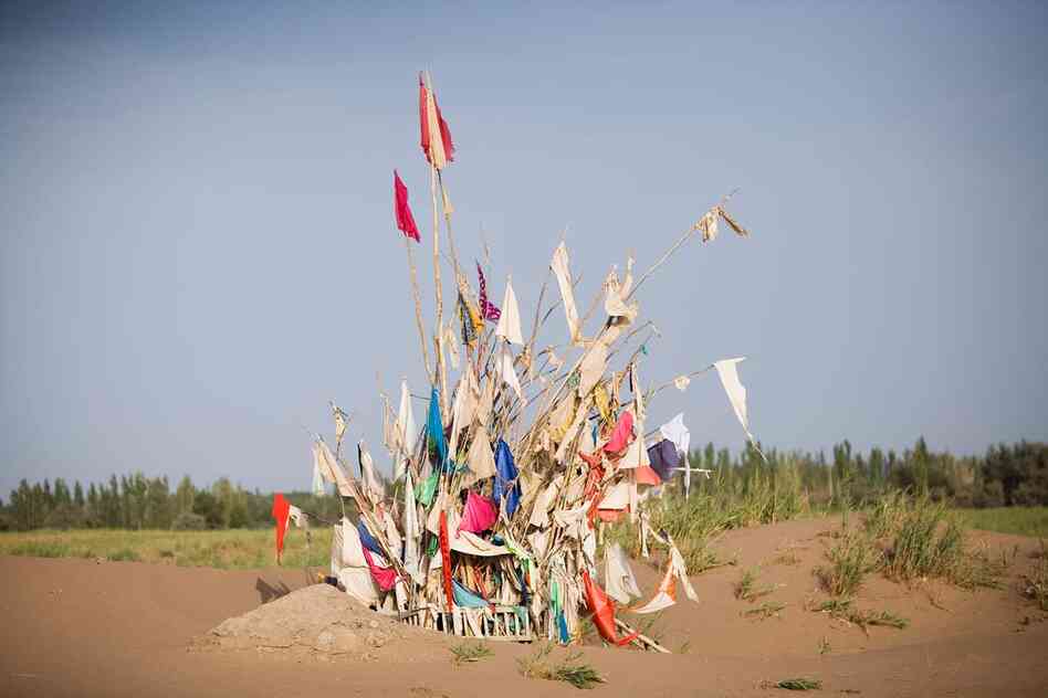 Unrevealed, Site 3 (Harvest Prayers), 2010. Markers for saints in the desert are maintained by shaykhs, who dig out the sands that would otherwise cover them over time. The number of flags on a marker correlates to a saint's power at performing miracles.