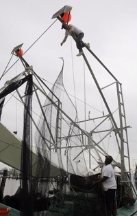 John Berthelot, top, and Hosea Wilson, bottom right, release the nets from their shrimp boat, Monday, May 3, 2010, at the Venice Marina in Venice, La.