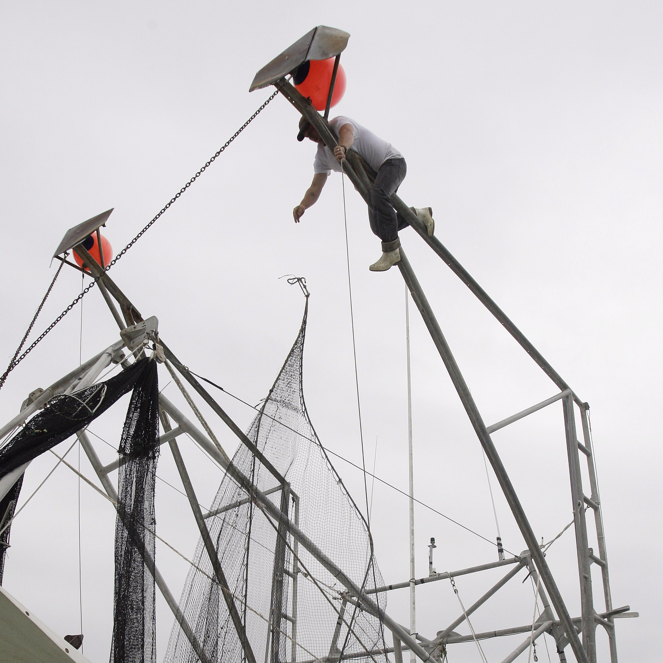 John Berthelot, top, and Hosea Wilson, bottom right, release the nets from their shrimp boat, Monday, May 3, 2010, at the Venice Marina in Venice, La.