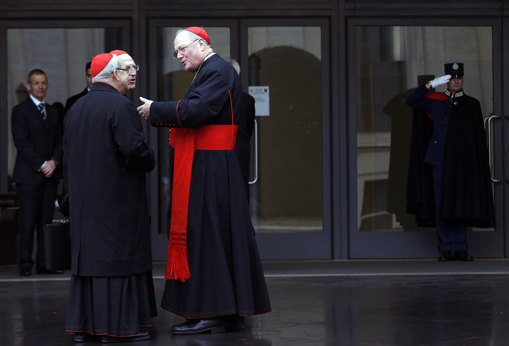U.S. Cardinal Timothy Dolan (right) chats with other cardinals as they arrive for a meeting at the Synod Hall in the Vatican on Thursday.
