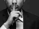 A man makes a "silence" gesture. A man makes a "silence" gesture.