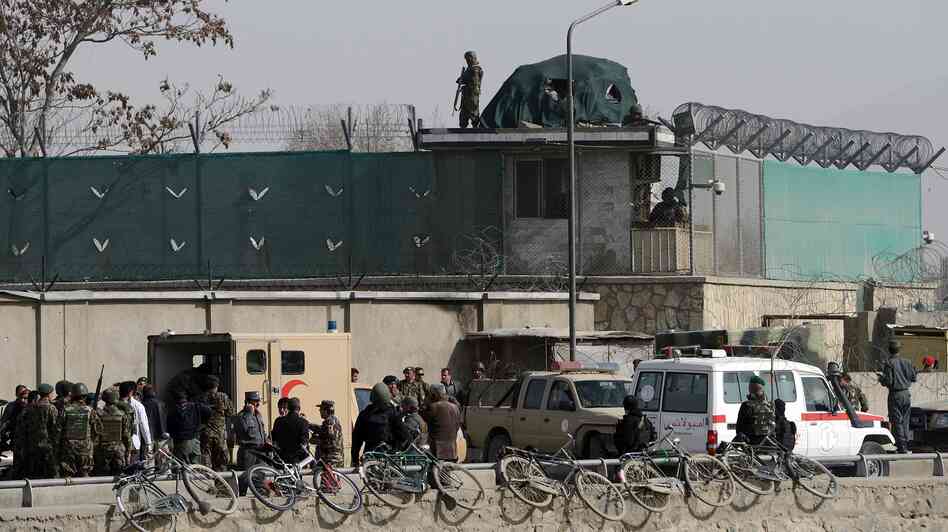 Afghanistan National Army soldiers and security personnel walk at the site of a suicide attack next to the Ministry of Defense main gate in Kabul on Saturday.