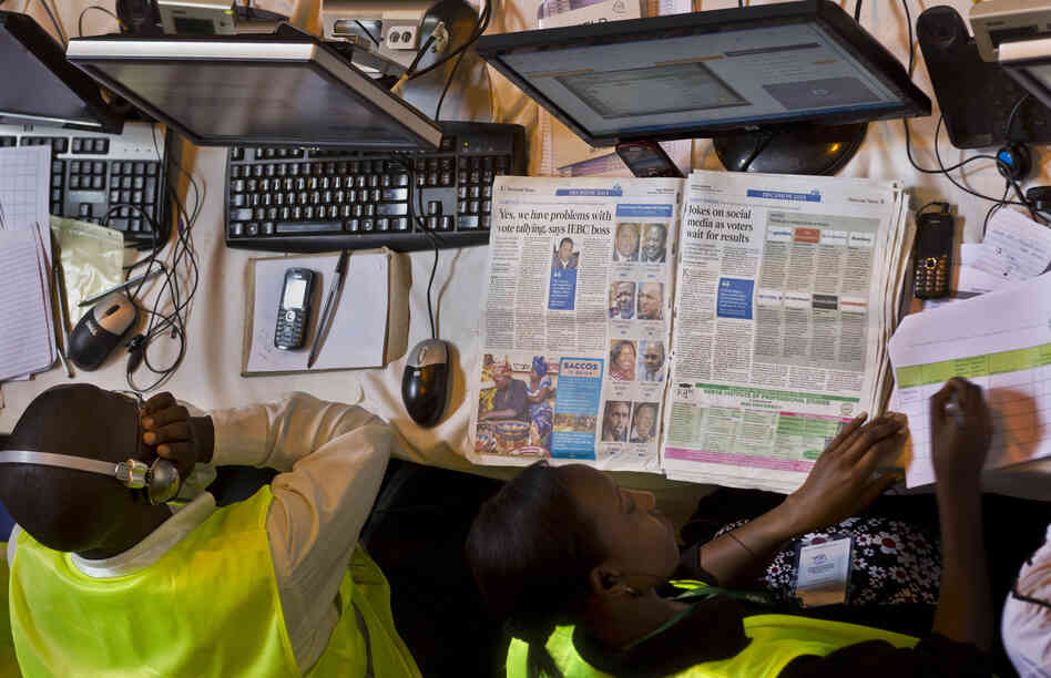 An electoral worker at the National Tallying Center reads a newspaper headlining the problems in the vote counting and tallying process in Kenya this week. Election officials had to count the ballots from the nation's presidential election by hand after abandoning the electronic tabulation system.