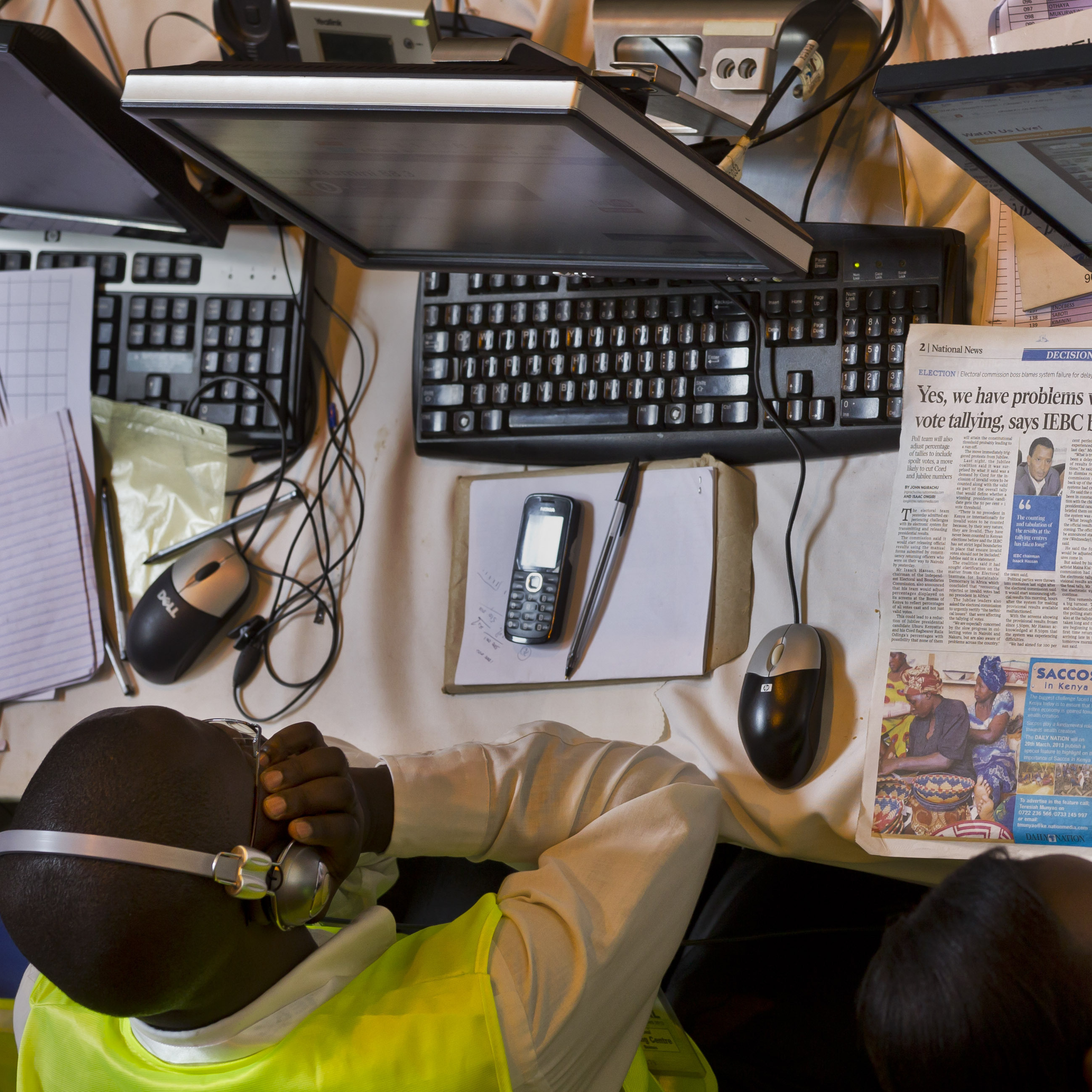 An electoral worker at the National Tallying Center reads a newspaper headlining the problems in the vote counting and tallying process in Kenya this week. Election officials had to count the ballots from the nation's presidential election by hand after abandoning the electronic tabulation system.