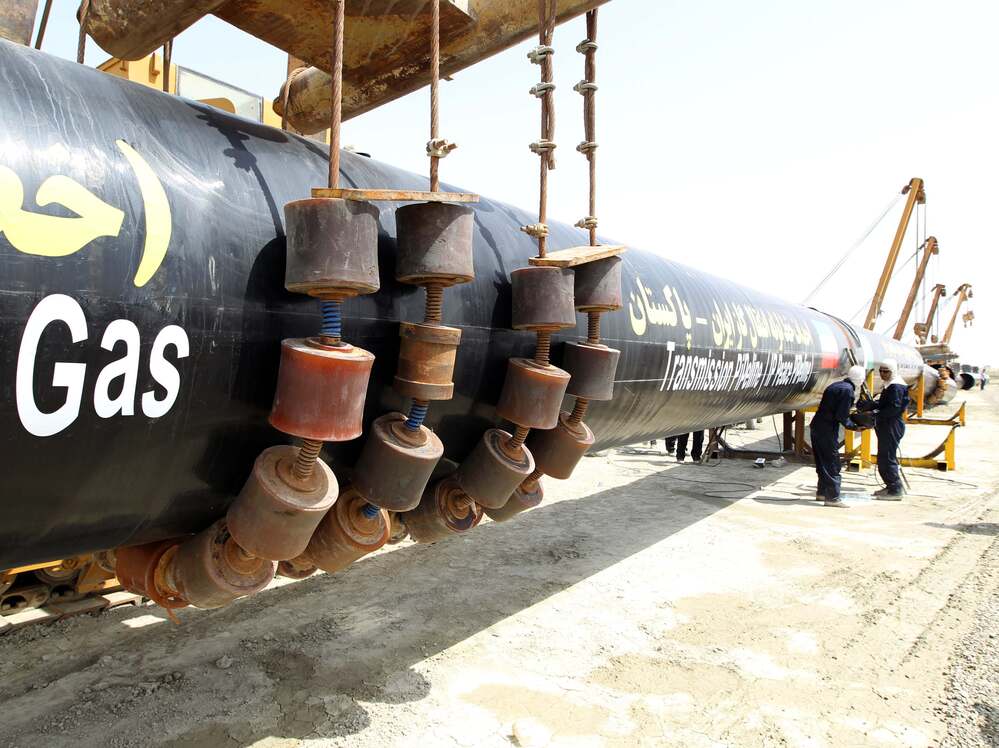 Iranians work on a section of the pipeline on Monday.