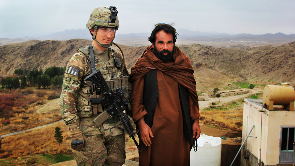 The U.S. military is increasingly focused on helping the Afghan government and security forces become self-sufficient. Here, U.S. Army 1st Lt. Phillip Baki visits with an Afghan police officer, Abdul Karim, at a checkpoint overlooking the Dahla Dam in the southern province of Kandahar.