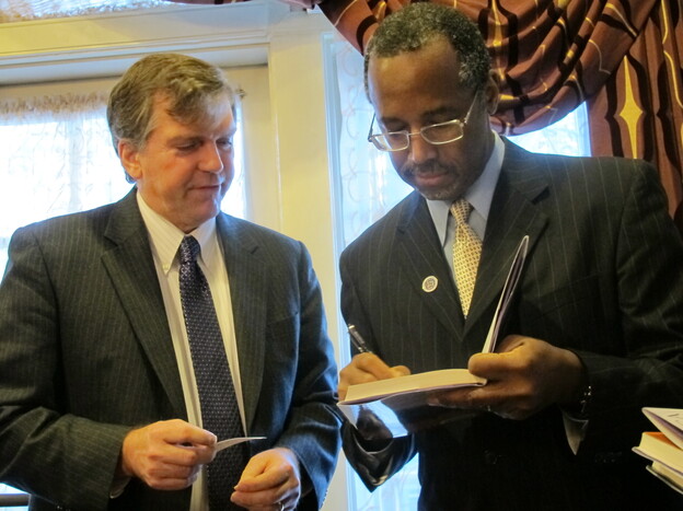 Dr. Ben Carson, right, signs a book for Delegate William Frank in Annapolis, Md., on Friday.