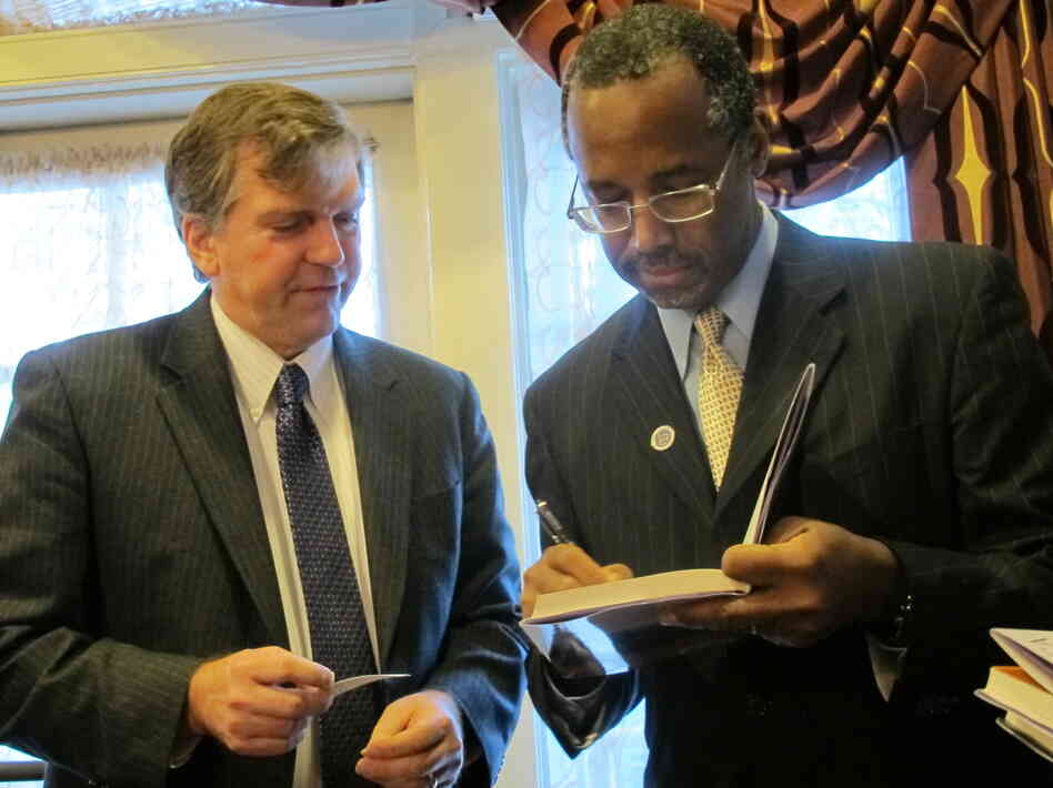 Dr. Ben Carson, right, signs a book for Delegate William Frank in Annapolis, Md., on Friday.