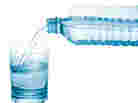 Water pouring from a bottle into a glass. Water pouring from a bottle into a glass.