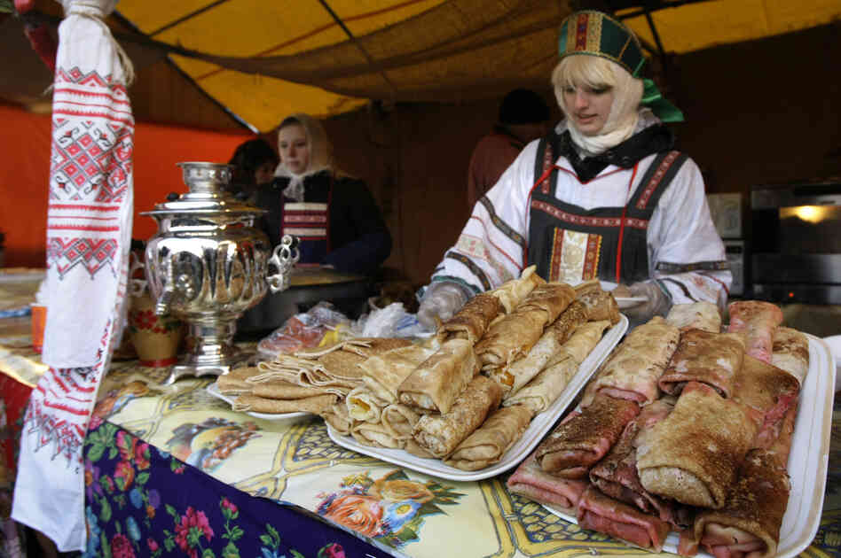 A vendor sells blini at a booth camp just outside the Kremlin in Moscow during Maslenitsa, February 2009. Each day of the week calls for prescribed activities. For example, on Sunday, the final day of the event, people are supposed to seek forgiveness from friends and strangers.
