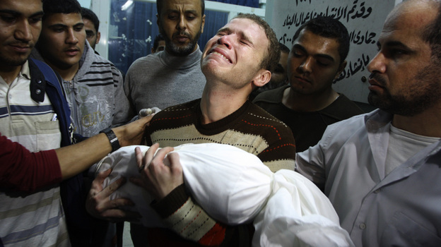 Jihad Masharawi weeps while he holds the body of his 11-month old son Ahmad. (AP)