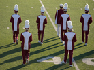 A marching band performs at halftime on the field during a high school football game. A marching band performs at halftime on the field during a high school football game.