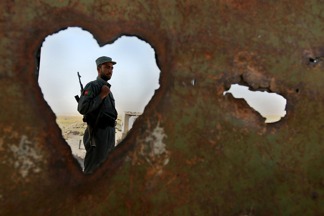 An Afghan policeman is seen through a hole at a police checkpoint on the outskirts of Kabul, 2007. An Afghan policeman is seen through a hole at a police checkpoint on the outskirts of Kabul, 2007.