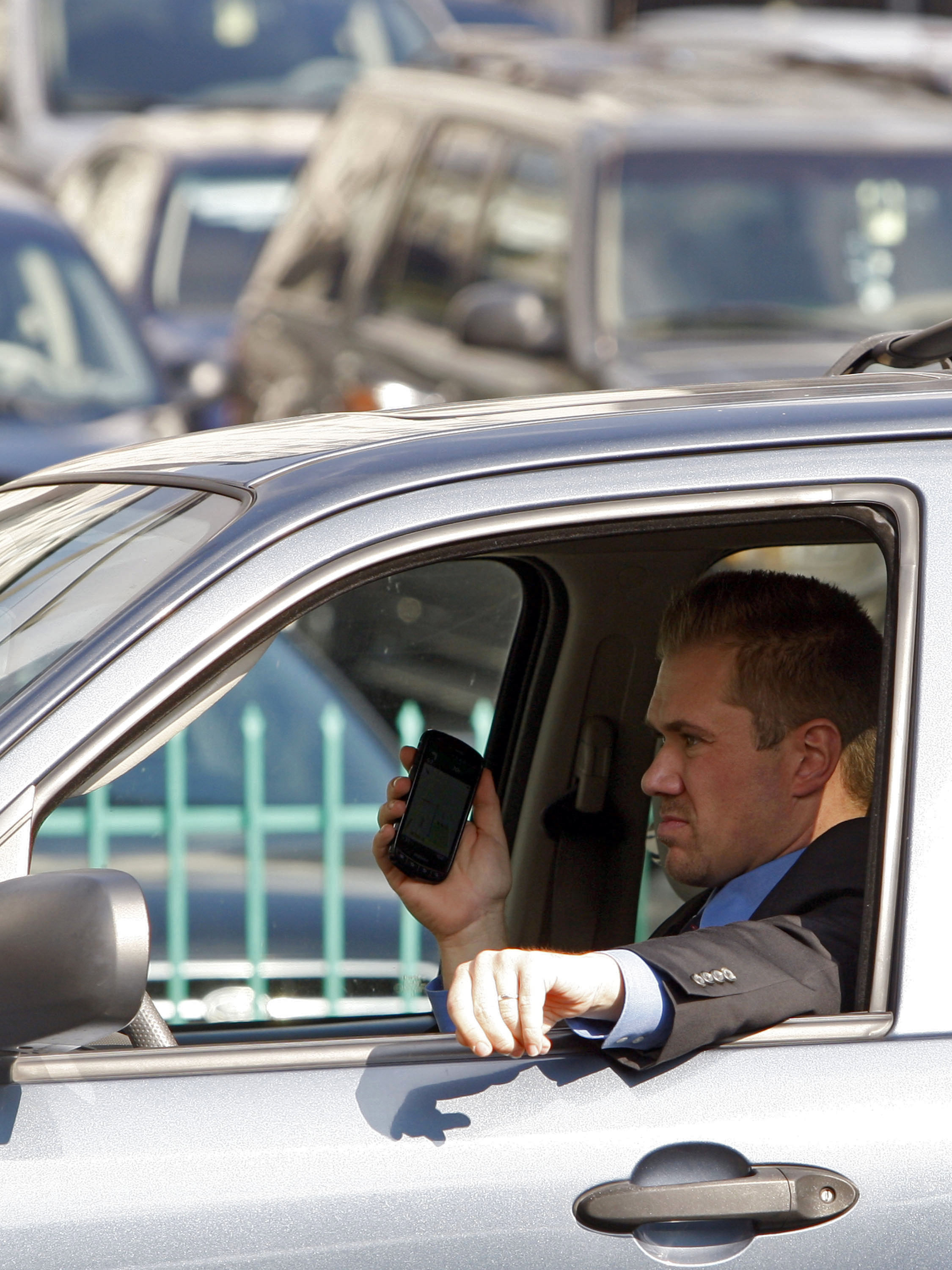 A driver uses a cellphone while driving Wednesday, Dec. 14, 2011, downtown Los Angeles.