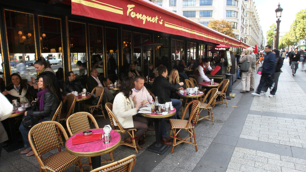 Diners eat at Fouquet's restaurant, a landmark on the Champs Elysees in Paris for more than a century. Traditional cafes and shops are steadily giving way to large global chains.