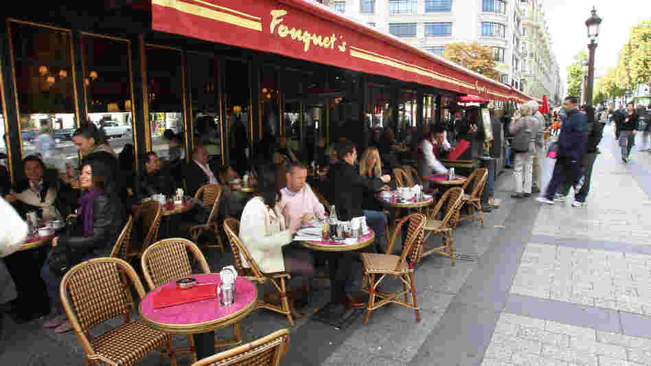 Diners eat at Fouquet's restaurant, a landmark on the Champs Elysees in Paris for more than a century. Traditional cafes and shops are steadily giving way to large global chains.