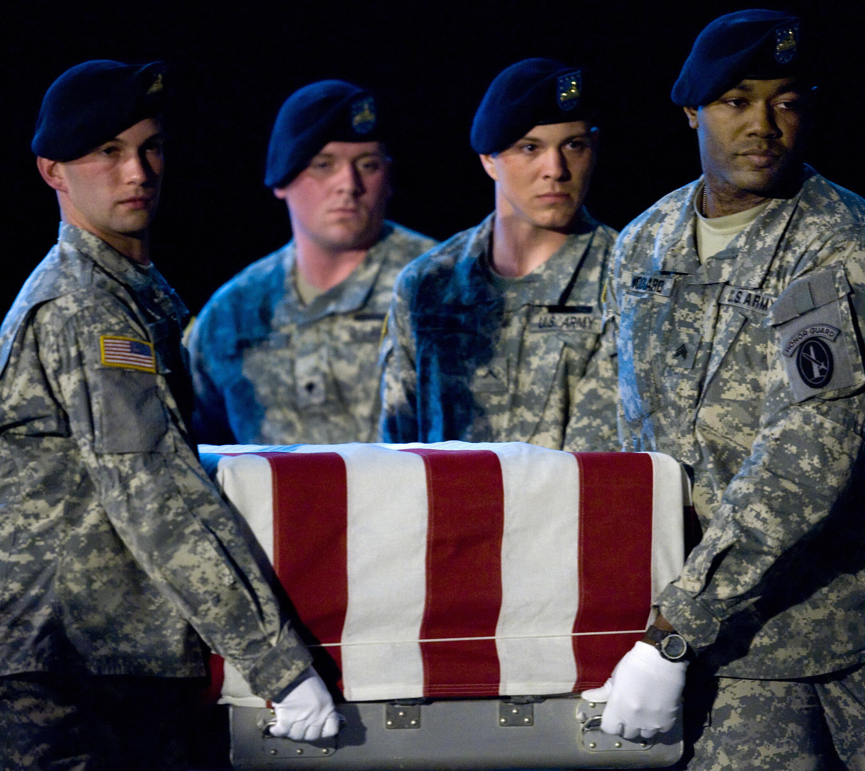 Members of the US Army's Old Guard carry team lift the remains of U.S. Army Specialist Israel Candelaria Mejias from San Lorenzo, Puerto Rico, as his body is returned on a C-17 to the U.S. from Iraq on April 7, 2009.