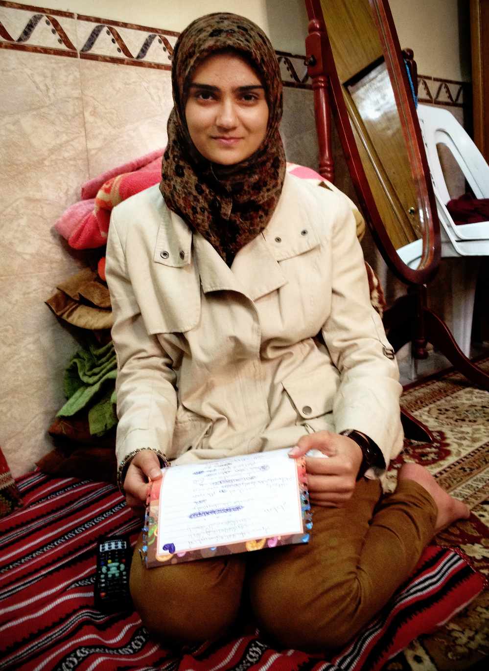 Guffran, 16, sits on the floor of her home, holding a letter she wrote to her father. A Shiite Muslim, Guffran's father was gunned down on the streets of Baghdad in 2006.