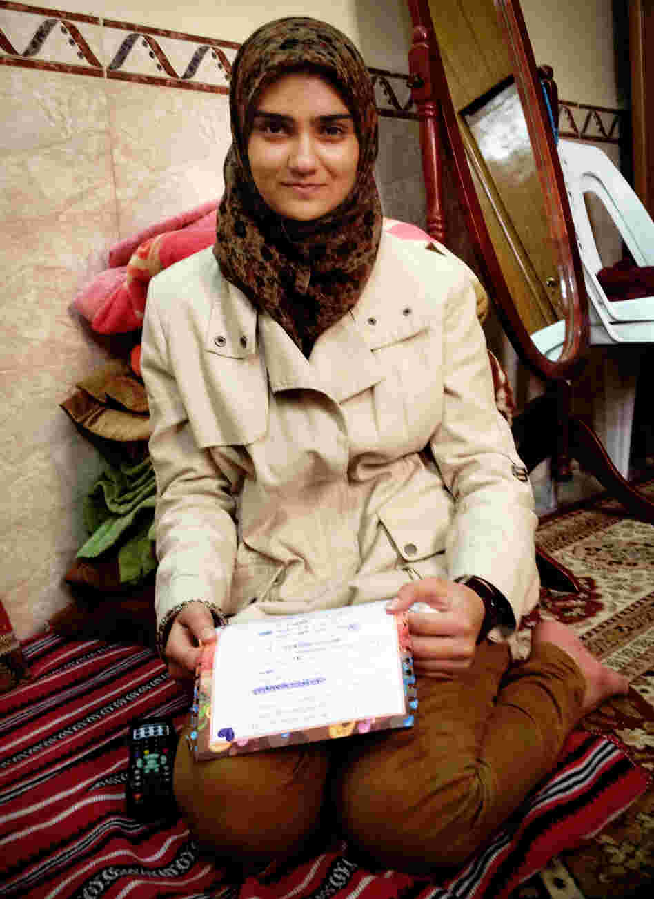 Guffran, 16, sits on the floor of her home, holding a letter she wrote to her father. A Shiite Muslim, Guffran's father was gunned down on the streets of Baghdad in 2006.