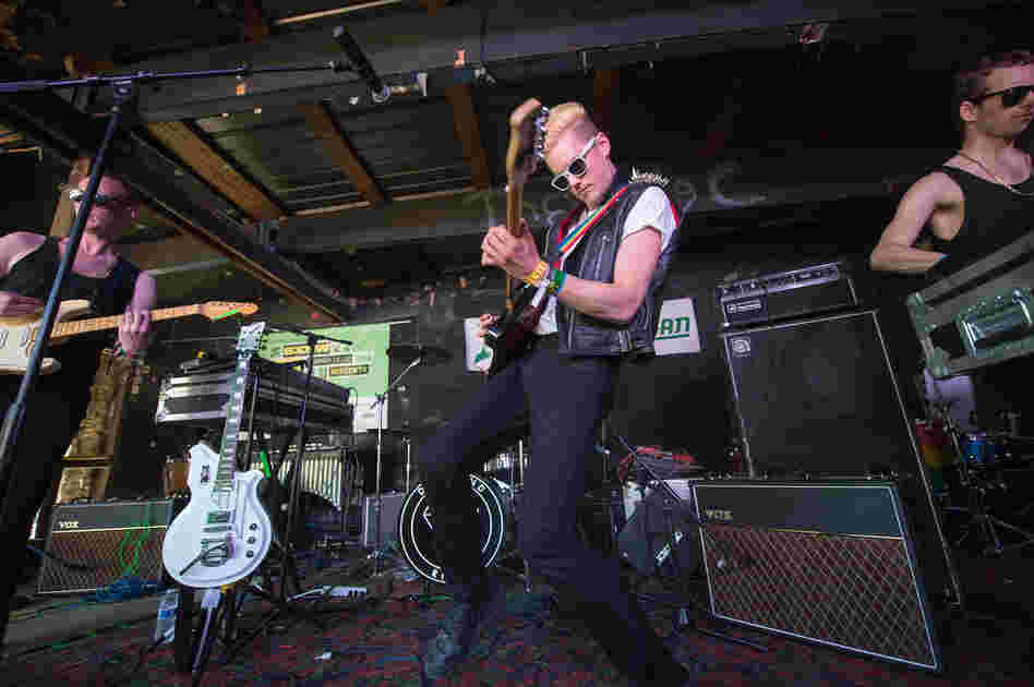 Sporting a studded leather jacket and a rainbow guitar strap, Diamond Rings' John O'Regan (center) glams and glums out The Main. 