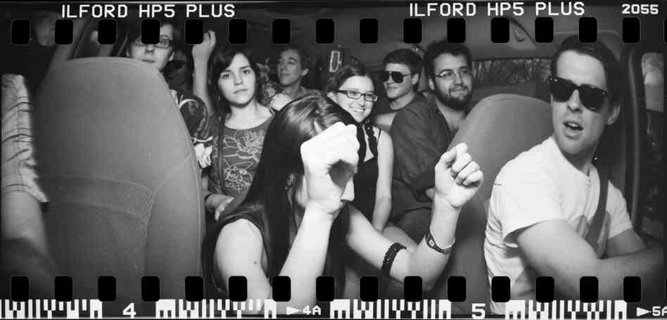 A 14-passenger van is filled to capacity with band members and instruments. A 14-passenger van is filled to capacity with band members and instruments.