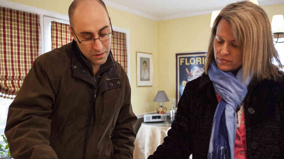 Patrick Bove, a homebuyer (and seller), and Redfin real estate agent Lynn Ikle look at a pamphlet at an open house in Towson, Md.