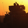 A soldier in the last American military convoy to depart Iraq, from the 3rd Brigade, 1st Cavalry Division, waves after crossing over the border into Kuwait on Dec. 18, 2011.