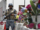 An Iraqi policeman stands guard at a checkpoint decorated with plastic flowers in Baghdad in 2008. An Iraqi policeman stands guard at a checkpoint decorated with plastic flowers in Baghdad in 2008.