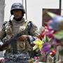 An Iraqi policeman stands guard at a checkpoint decorated with plastic flowers in Baghdad in 2008.