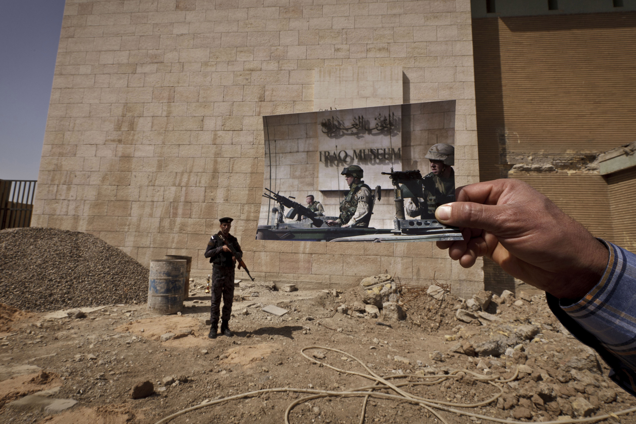 Today, Iraqi policeman Ahmed Naji stands on the grounds of the Iraqi National Museum — which was guarded by U.S. soldiers in the 2003 photo taken by Anja Niedringhaus. Tens of thousands of artifacts chronicling some 7,000 years of civilization in Mesopotamia are believed to have been looted from Iraq in the chaos the followed the the U.S.-led invasion in 2003.