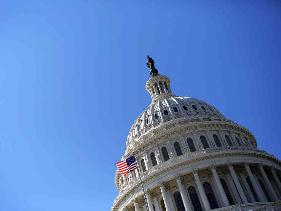 A U.S. flag flies in front of the dome of the U.S. Capitol February 12, 2013.