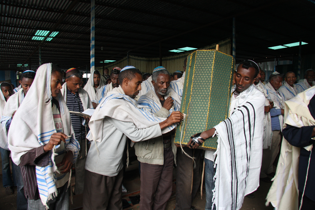 Men at morning prayers touch the Torah Scroll with the fringe of their prayer shawls at a Jewish compound in Gondar, June 2011.
