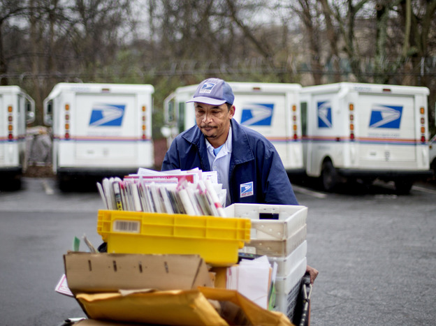 Veteran USPS letter carrier Michael McDonald gathers mail to load into his truck before making his delivery run in the East Atlanta neighborhood on Thursday, Feb. 7, 2013, in Atlanta.