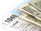 A 1040 tax form and cash. A 1040 tax form and cash.