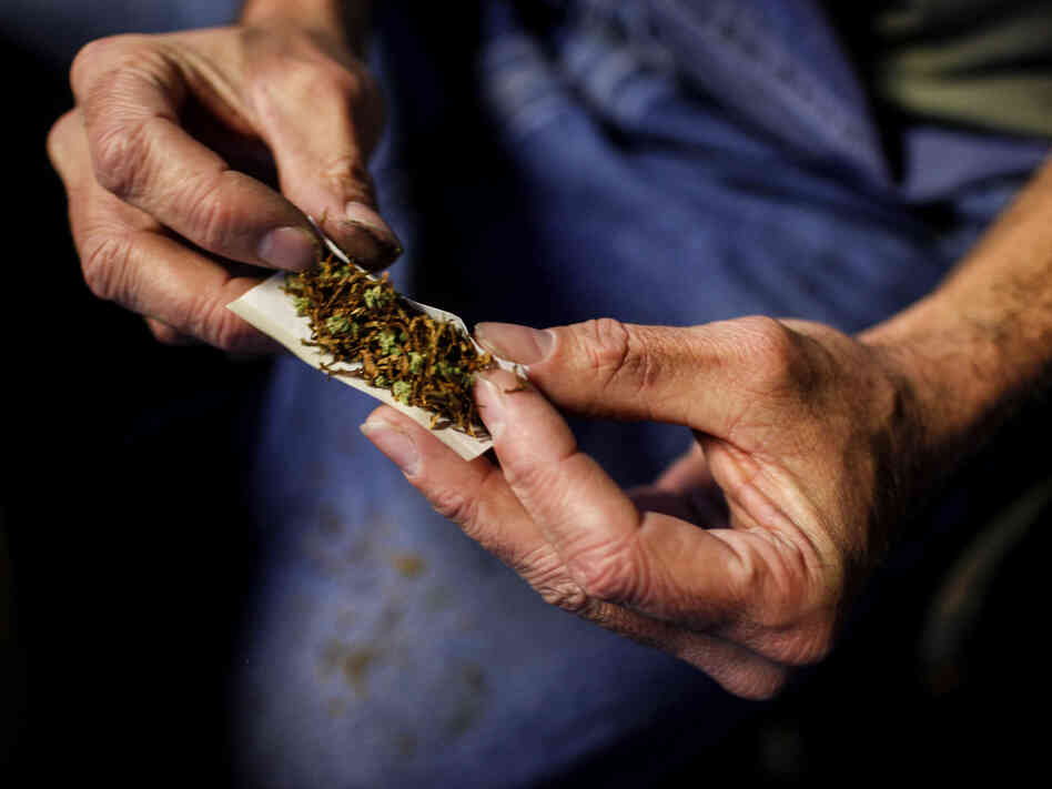 A customer rolls a joint made of half marijuana and half tobacco in Olympia, Wash., on December 9, 2012.
