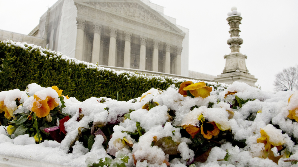 Snow covers flowers in front of the Supreme Court building on Monday in Washington, D.C. On Tuesday, the justices hear oral arguments on the constitutionality of California's Proposition 8, which banned gay marriage.