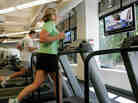 Chick-Fil-A employees Jennifer Cummins, right, and Joshua Figaretti work out in the gym during lunch at the company's corporate headquarters office in Hapeville, Ga. Increasingly employers are offering health plan incentives to encourage healthy behaviors from workers.