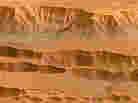 Coprates Chasma in the Valles Marineris on Mars, photographed by the Mars Express spacecraft. Appearing in the top half of this image, it ranges from 60-100 km wide and drops 8-9 km below the surrounding plains.