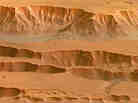 Coprates Chasma in the Valles Marineris on Mars, photographed by the Mars Express spacecraft. Appearing in the top half of this image, it ranges from 60-100 km wide and drops 8-9 km below the surrounding plains.