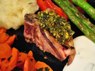 A lamb chop crusted with pistachio, mint and spices, served with assorted vegetables A lamb chop crusted with pistachio, mint and spices, served with assorted vegetables