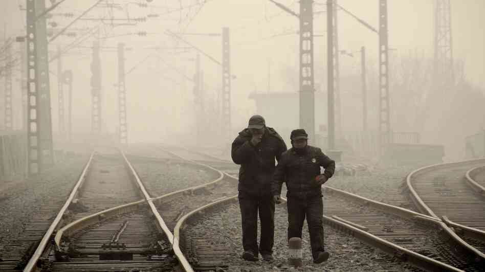 Men walk along a railway line in Beijing on Jan. 12, as air pollution reached hazardous levels. Men walk along a railway line in Beijing on Jan. 12, as air pollution reached hazardous levels.